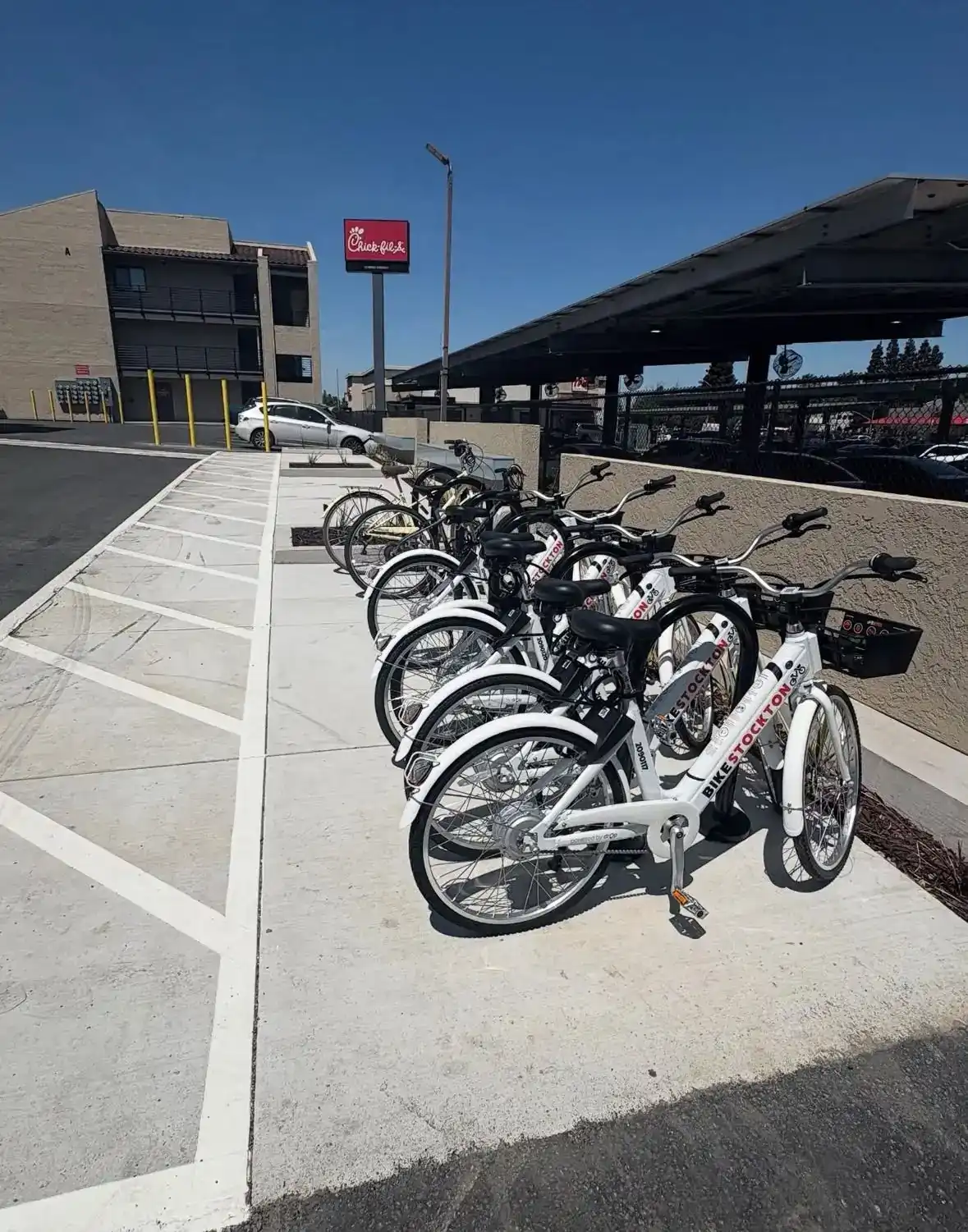 New concrete flatwork with a row of bike-share racks