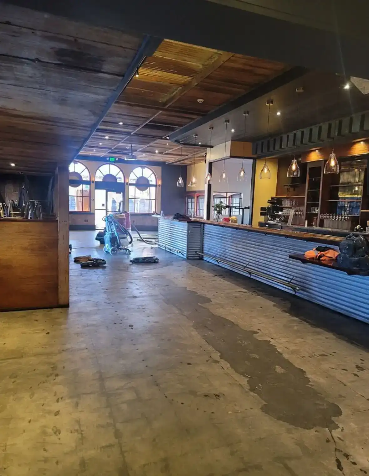 Restaurant interior mid-renovation with new bar millwork and bare concrete floor
