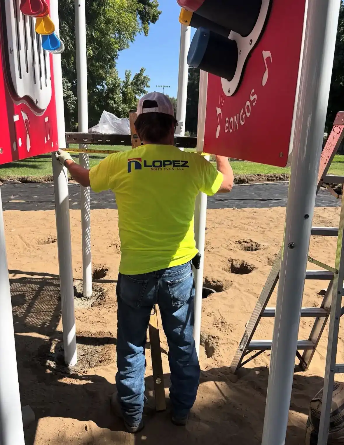 Lopez crew member setting a steel post on an active site