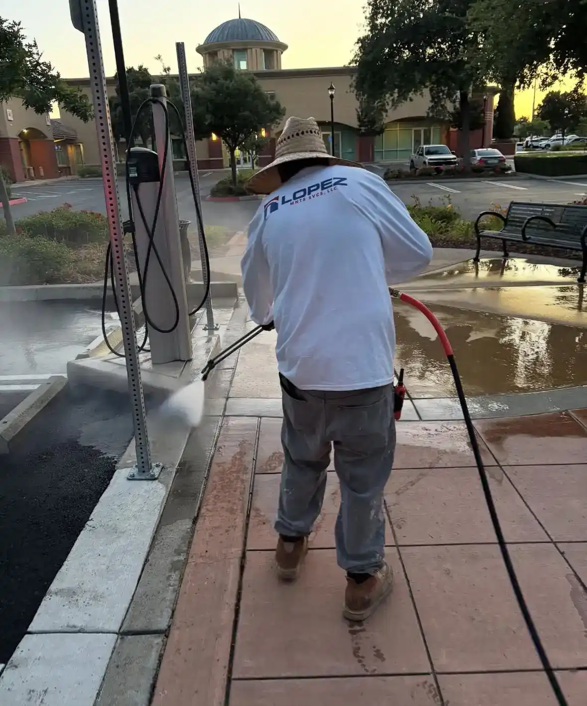 Crew member pressure washing a public plaza